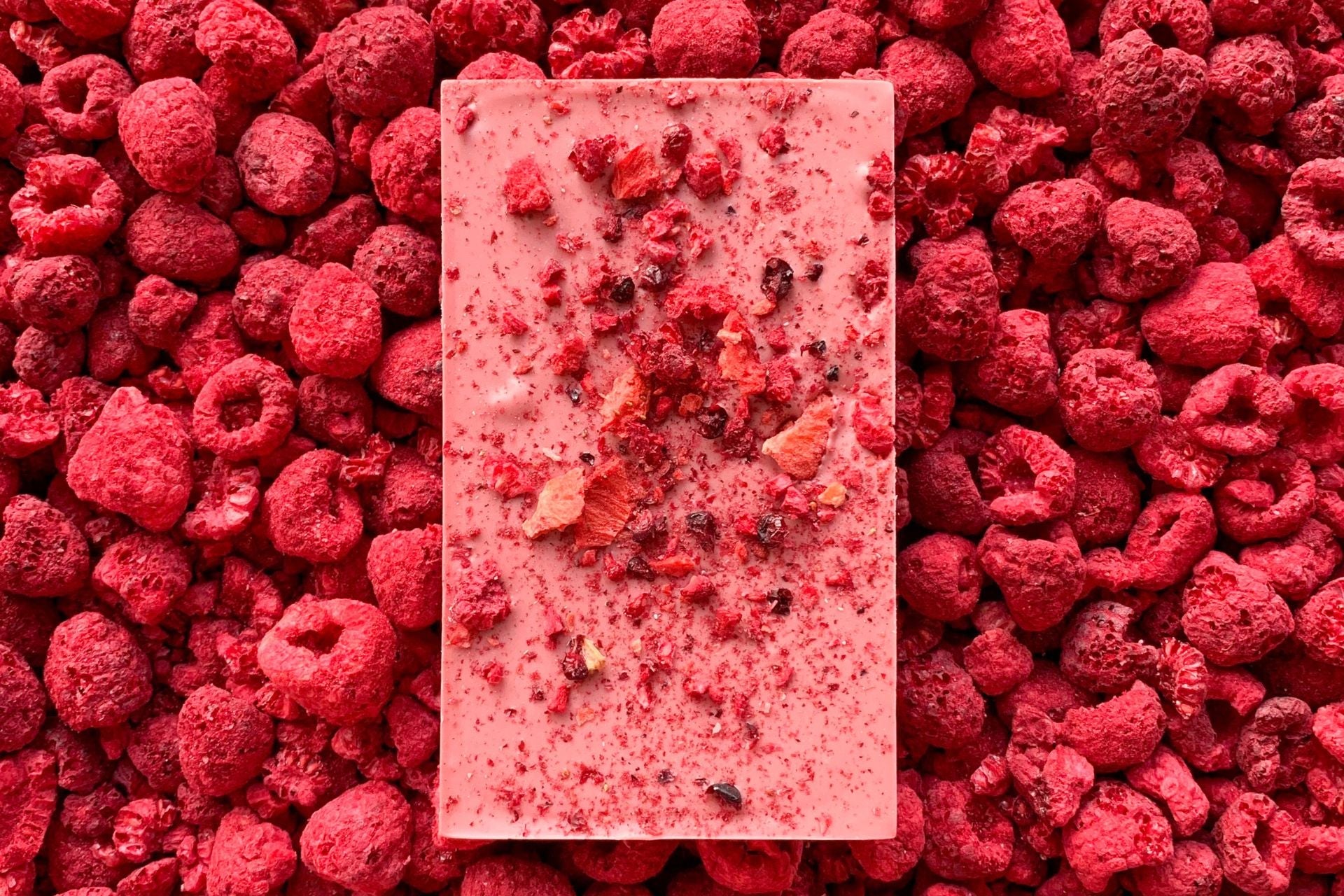 A ruby chocolate bar, handmade by Alicja Confections, covered with freeze dried berries